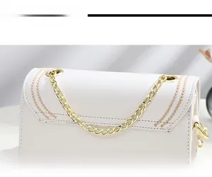 Détail d'un sac bandoulière blanc avec chaîne dorée et coutures décoratives