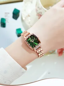Detail of rose gold quartz watch with a green rectangular dial and diamond accents