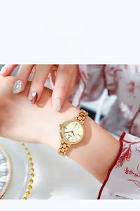 Dettaglio dell'orologio da donna dorato con indici in strass e cinturino a maglie in metallo