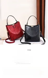 Detail of red and black croc-embossed bucket bags with gold hardware and top handles