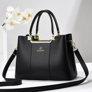 Elegant black lychee leather handbag for women with gold hardware and three compartments