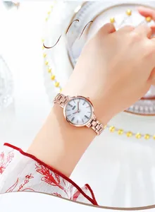 Dettaglio dell'orologio da donna in oro rosa con quadrante in madreperla e piccoli diamanti