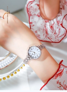 Dettaglio dell'orologio in acciaio argento con quadrante in strass al polso femminile