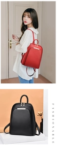 Minimalist leather backpack for women featuring metal trim and versatile carrying handles