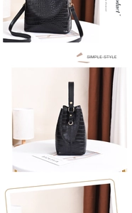 Detail of black crocodile texture bucket bag with gold hardware and versatile straps