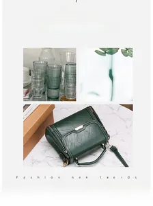 Détail d'un sac à main rétro vert foncé avec texture litchi et touches dorées