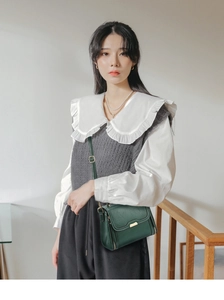 Vue détaillée du sac bandoulière en cuir vert foncé avec fermoir en métal et zips