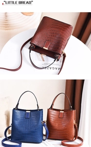 Detail of stone embossed texture on brown and blue bucket bags with gold buckles