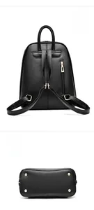 Detail view of black leather backpack showing anti-theft back pocket and metal base studs