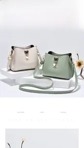 Detail of cream and green bucket bags with star charms and gold hardware on white stands
