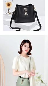 Detail of elegant black and green bucket bags with heart metal charm on white pedestal