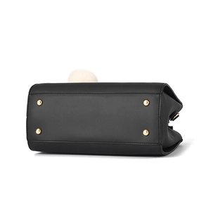 Borsa a mano in pelle nera con piedini dorati e ciondolo di peluche bianco su fondo bianco