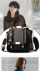 Detail of vintage texture black handbag with brown handles and a wide printed strap