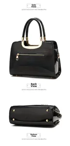 Detail of glossy black patent leather handbag featuring gold hardware and bottom studs