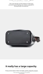 Detail of black leather bucket bag bottom featuring protective metal rivets and striped strap