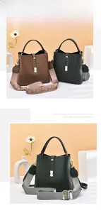 Detail of soft leather bucket bag featuring wide shoulder strap and metal hardware