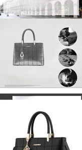Detailed view of black checkered handbag with gold logo, tassels and pearl pendant