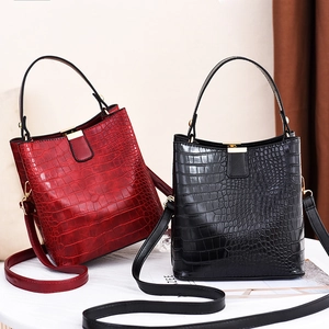 Sac seau à motif pierre en rouge et noir avec des détails métalliques dorés chic