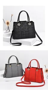 Detailansicht stilvoller geprägter Ledertaschen in Schwarz, Grau und Rot mit Goldringen