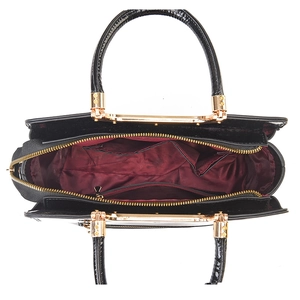 Glossy black patent leather tote bag with red interior compartments and golden hardware