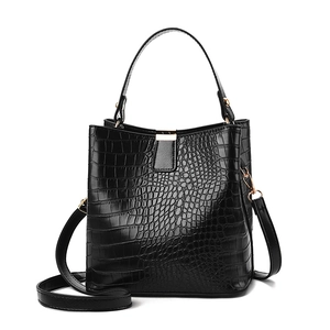 Sac seau noir brillant à motif crocodile avec finitions dorées et poignée