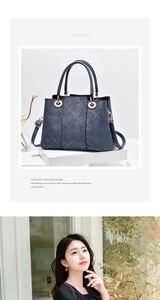 Detail einer dunkelblauen Ledertasche mit geometrischer Textur und goldenem Metallringgriff