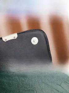 Détails du fermoir magnétique et du cuir grainé vert sur un sac à main rétro