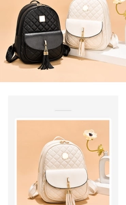 Détail d'un sac à dos matelassé avec pompon en chaîne dorée et boucle métallique