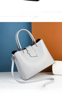 Rear view of minimalist light grey leather handbag with silver hardware and shoulder strap