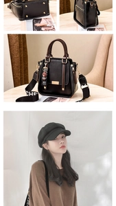 Detail of black lychee grain handbag featuring brown leather handles and a bear charm