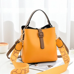 Sac seau chic en cuir jaune avec poignée marron et large bandoulière à motifs
