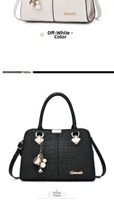 Close-up of elegant crocodile embossed leather handbag with gold hardware and charm detail