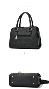 Detail view of black crocodile pattern handbag with heart zipper and protective gold studs