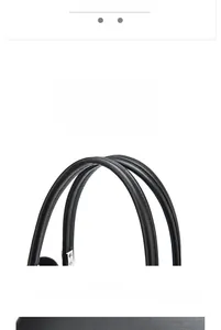 Close-up of the black leather handbag handle showing fine texture and precise stitching