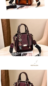 Close-up of wine red faux leather bag with lychee texture and fabric wide shoulder strap