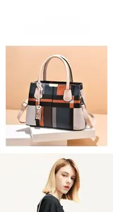 Detailed view of large plaid tote bag with color-block panels and golden metal tag