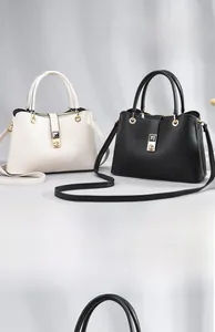 Detail of vintage tote bags in cream and black featuring lychee texture and gold hardware