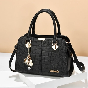 Elegant black crocodile-pattern leather handbag with gold hardware on white display stands