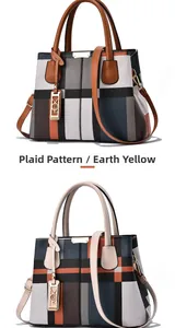 Detail of plaid tote bag featuring leather handles and gold metal decorative hardware