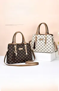 Detail of elegant patterned tote bags with metallic tassel charms and dual handles