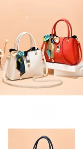 Detail of red and cream leather tote bags with silk scarves and gold hardware