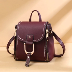 Close-up of burgundy PU leather bag with golden D-ring buckle and contrast stitching