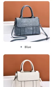 Detail of elegant handbag with crocodile embossed texture in blue and off-white colors