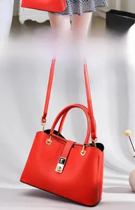 Close-up of red lychee pattern tote bag with gold hardware and adjustable strap