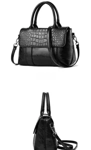 Detail view of the black handbag showing premium crocodile pattern embossing and silver hardware