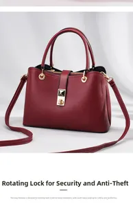Close-up of golden rotating lock and lychee grain texture on wine red handbag