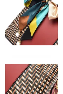Close-up of red leather and houndstooth handbag with silk scarf and pearl detail