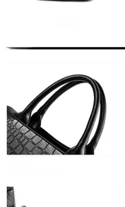 Detail view of black crocodile pattern leather handbag with comfortable double top handles