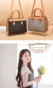 Close-up of classic printed leather handbag with gold hardware and removable shoulder strap