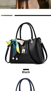 Detail of black pebbled leather handbag with gold metal lock and silk scarf ornament